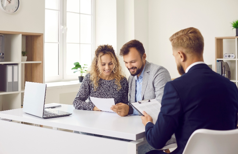 Happy clients sitting at desk in lawyer office