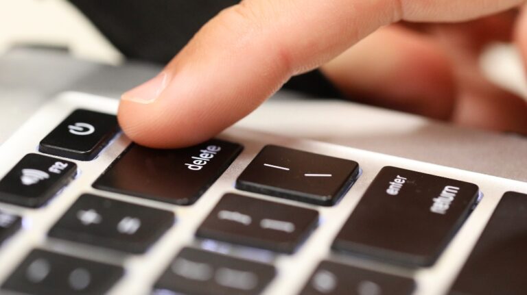 finger about to push the delete key on a computer keyboard