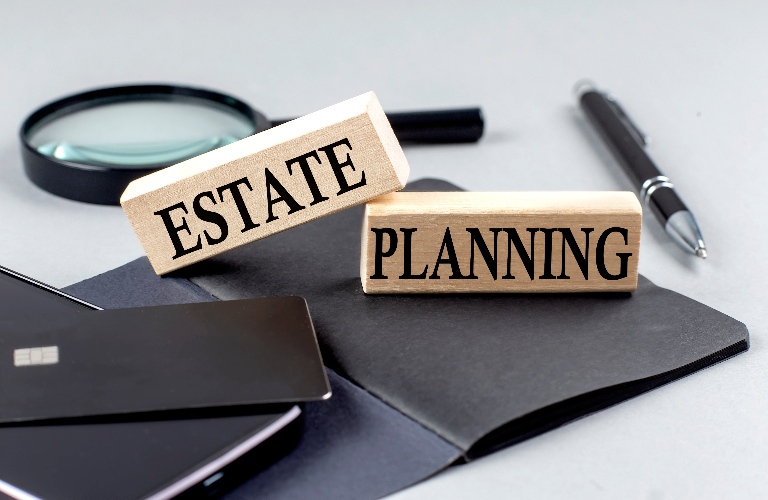 ESTATE PLANNING text on a wooden block on black notebook