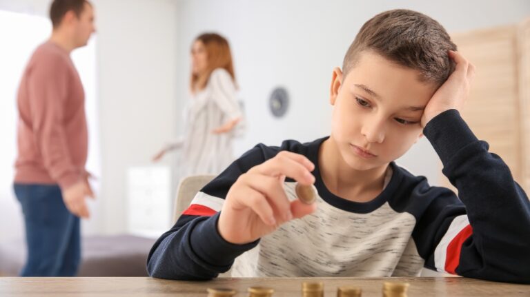 Sad little boy with coins and his quarreling divorced parents