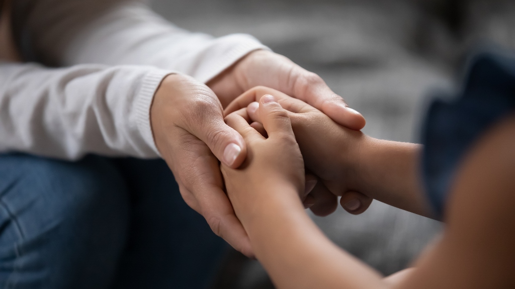 mom is holding child's hands