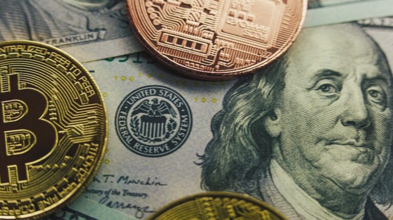 Golden bitcoin coins and hundred dollar bills